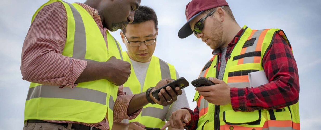 three men on mobile phones working on GIS project